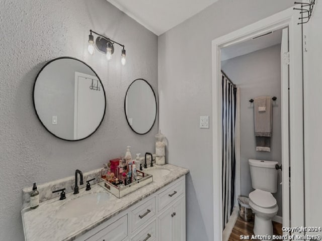 bathroom with wood-type flooring, vanity, toilet, and a shower with curtain