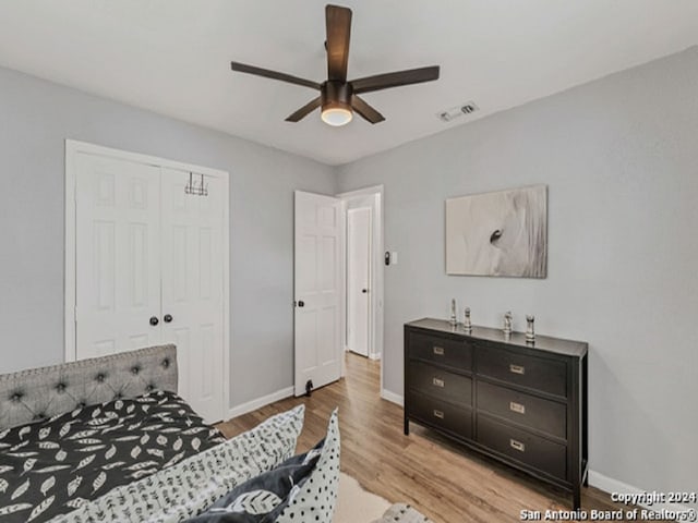 bedroom featuring light hardwood / wood-style flooring, a closet, and ceiling fan