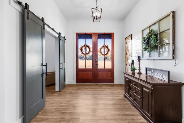 345 Judges Rd, Burnet, TX 78611 - entrance foyer with a barn door, french doors, light wood-type flooring, and a chandelier
