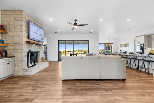 345 Judges Rd, Burnet, TX 78611 - living area featuring a ceiling fan, a fireplace, recessed lighting, light wood finished floors, and a chandelier
