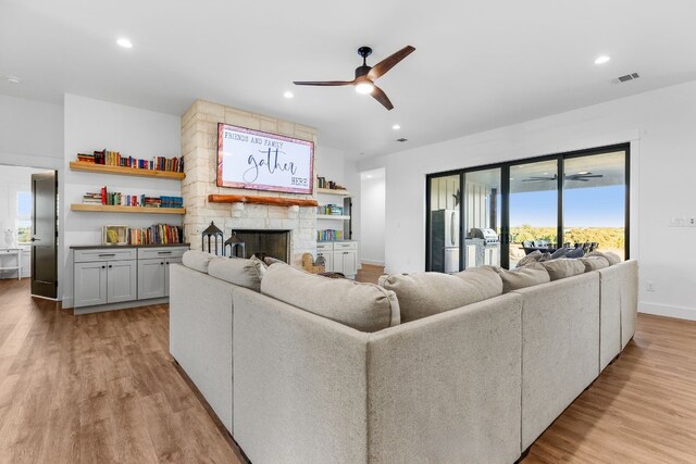 345 Judges Rd, Burnet, TX 78611 - living room featuring ceiling fan, light wood-type flooring, a stone fireplace, and recessed lighting