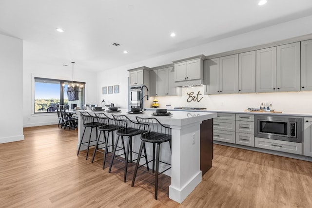 345 Judges Rd, Burnet, TX 78611 - kitchen with gray cabinets, appliances with stainless steel finishes, a chandelier, a center island with sink, and a kitchen bar