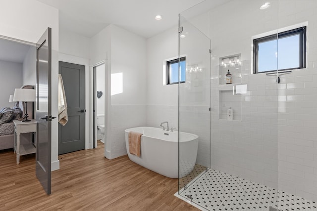 345 Judges Rd, Burnet, TX 78611 - bathroom with a soaking tub, wood finished floors, and a tile shower