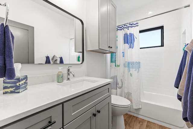 full bathroom featuring vanity, wood-type flooring, shower / tub combo, and toilet