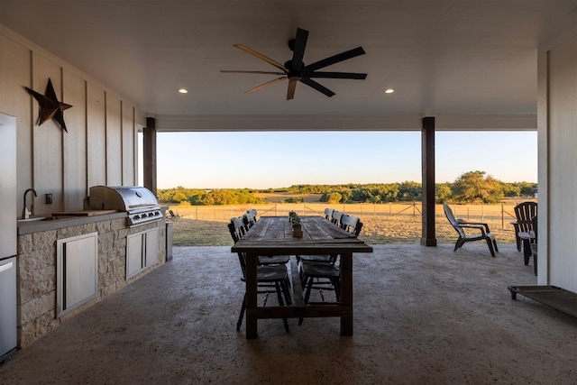 view of patio featuring grilling area, ceiling fan, area for grilling, and a rural view