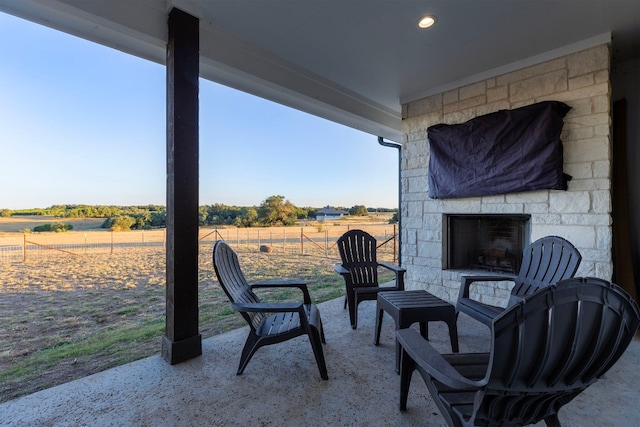 view of patio / terrace featuring a rural view and an outdoor stone fireplace