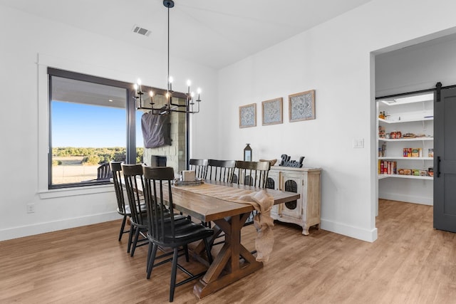 345 Judges Rd, Burnet, TX 78611 - dining area with a chandelier, light wood-type flooring, and a barn door