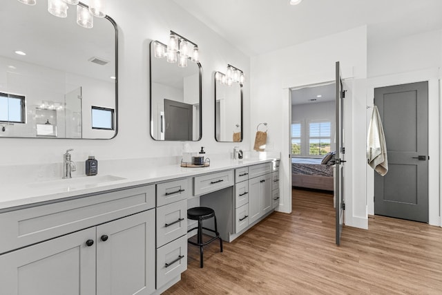 345 Judges Rd, Burnet, TX 78611 - full bath with double vanity, wood finished floors, connected bathroom, a shower, and a chandelier