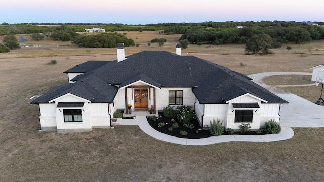 345 Judges Rd, Burnet, TX 78611 - view of front of house featuring board and batten siding, roof with shingles, a chimney, and french doors