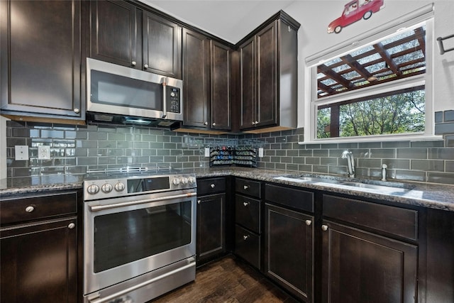 kitchen with dark brown cabinetry, sink, decorative backsplash, and stainless steel appliances