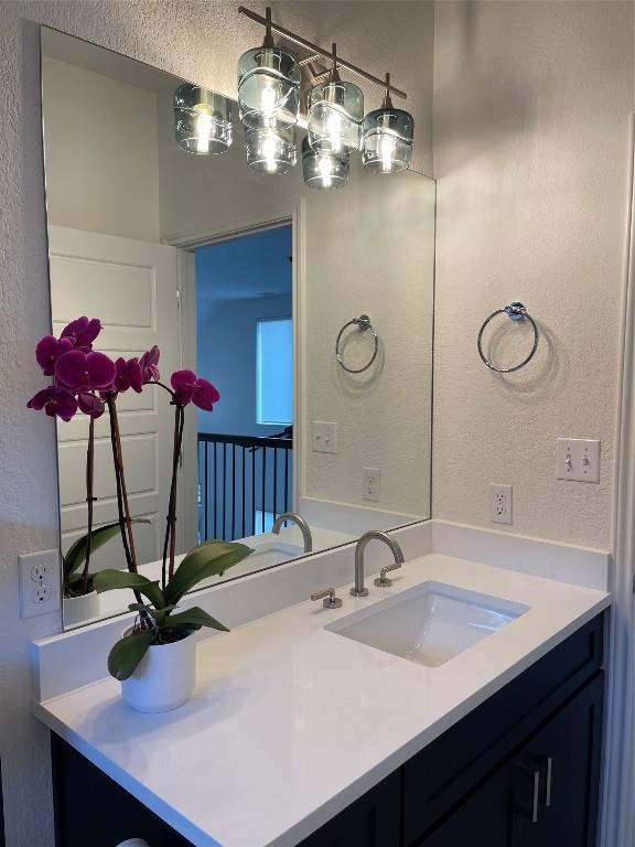 bathroom featuring vanity and a textured wall