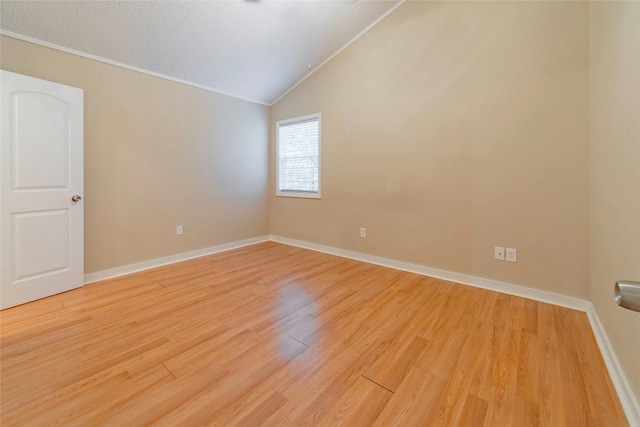 unfurnished room featuring lofted ceiling and light wood-type flooring