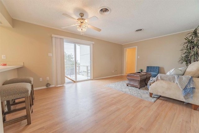 sitting room with ceiling fan, ornamental molding, and light hardwood / wood-style flooring