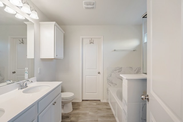 bathroom with a bath, hardwood / wood-style floors, toilet, vanity, and tile walls