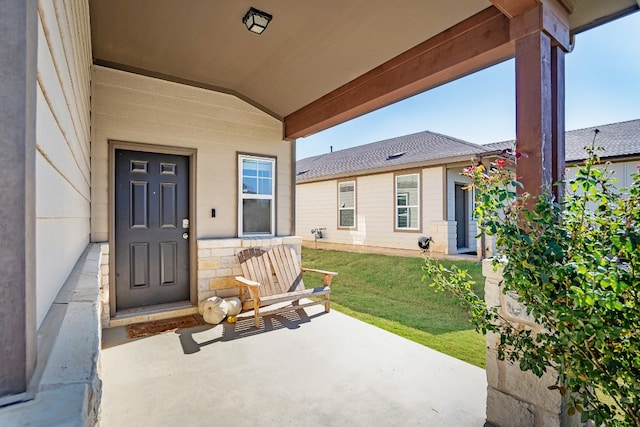 view of exterior entry with a yard