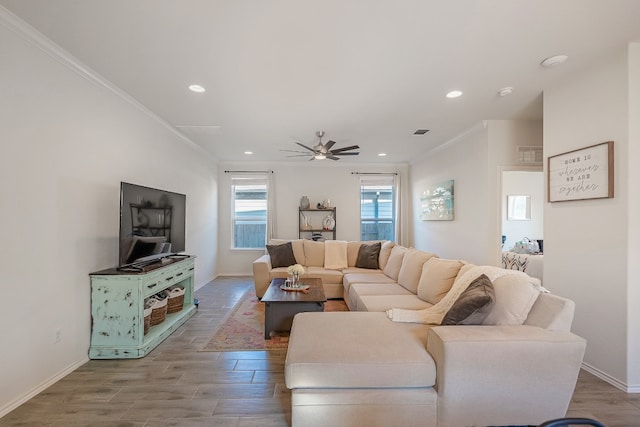 living room featuring ceiling fan, hardwood / wood-style flooring, and crown molding