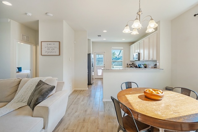 dining space featuring a chandelier and light hardwood / wood-style flooring