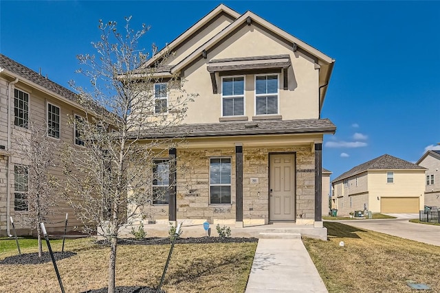 traditional-style house featuring stone siding, a front yard, a porch, and stucco siding