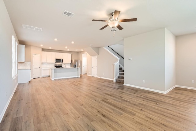 196 Lost Mine Peak Ln, Dripping Springs, TX 78620 - unfurnished living room featuring stairway, a ceiling fan, light wood-type flooring, recessed lighting, and baseboards