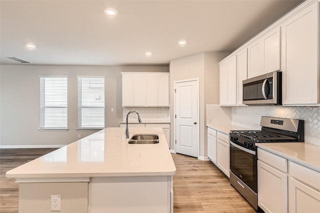 196 Lost Mine Peak Ln, Dripping Springs, TX 78620 - kitchen with appliances with stainless steel finishes, a sink, an island with sink, backsplash, and recessed lighting