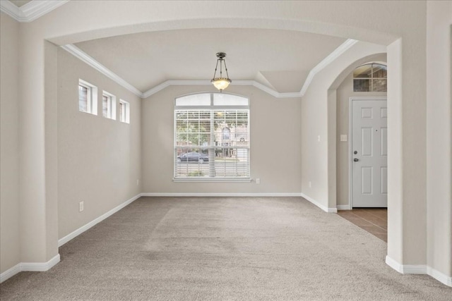 spare room featuring light colored carpet, ornamental molding, and vaulted ceiling