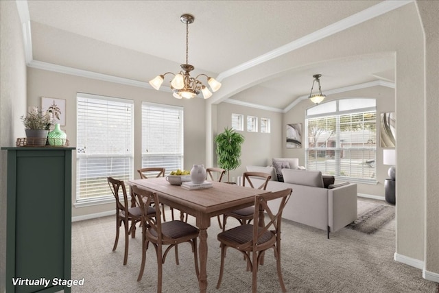 carpeted dining space featuring crown molding, a healthy amount of sunlight, lofted ceiling, and an inviting chandelier