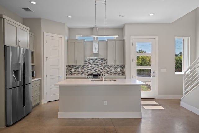 kitchen featuring backsplash, stainless steel appliances, decorative light fixtures, a center island with sink, and gray cabinets