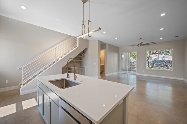 kitchen with stainless steel dishwasher, ceiling fan, sink, pendant lighting, and a center island with sink