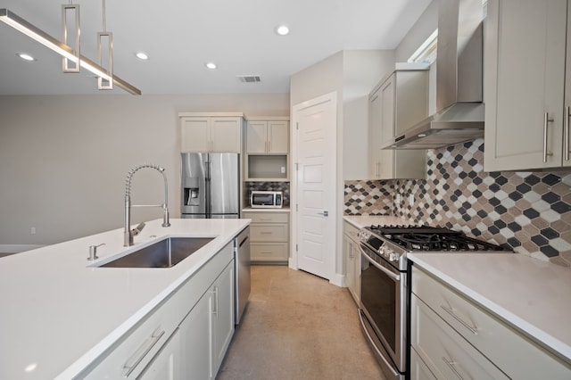 kitchen featuring sink, wall chimney exhaust hood, stainless steel appliances, backsplash, and decorative light fixtures