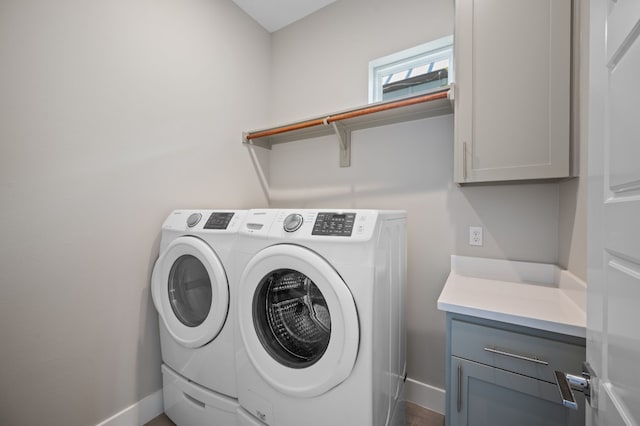 laundry room with washing machine and dryer and cabinets