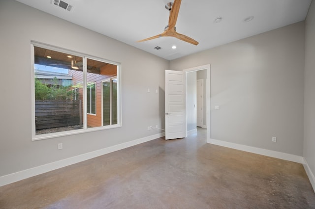 spare room featuring concrete floors and ceiling fan