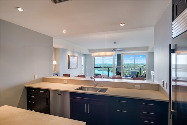 kitchen with kitchen peninsula, stainless steel appliances, ceiling fan, and sink