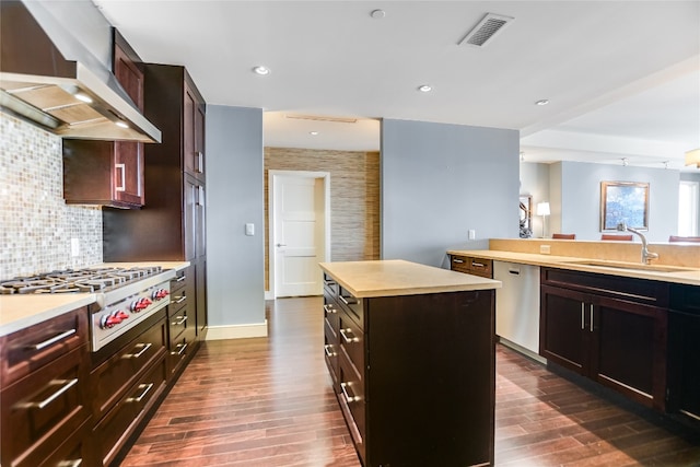 kitchen featuring a center island, stainless steel appliances, dark hardwood / wood-style floors, and wall chimney range hood