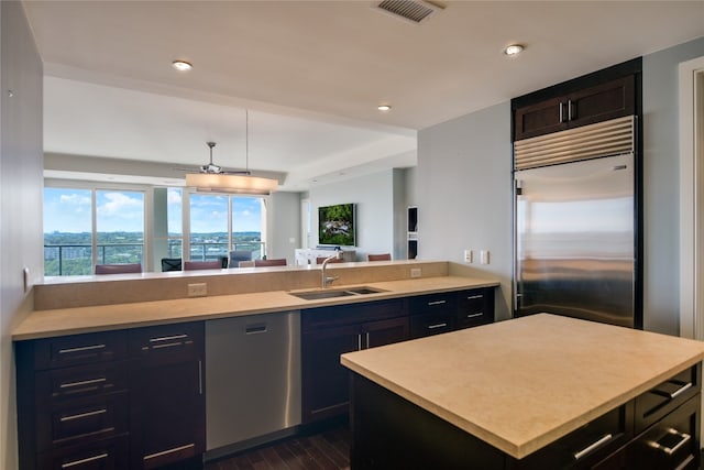 kitchen featuring appliances with stainless steel finishes, a center island, dark hardwood / wood-style flooring, and sink