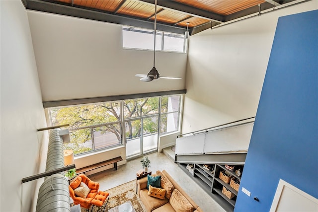 interior space featuring ceiling fan, plenty of natural light, wood ceiling, and concrete floors