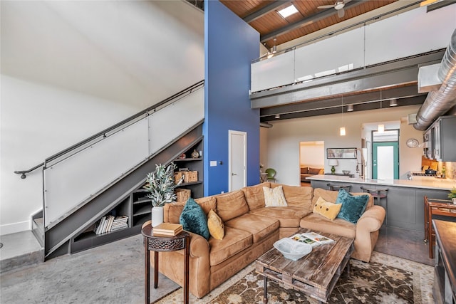 living room featuring a high ceiling, ceiling fan, and wood ceiling