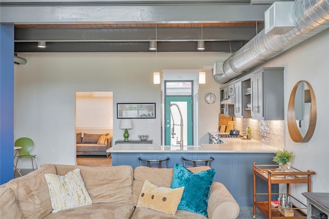 kitchen with gray cabinetry, pendant lighting, decorative backsplash, beam ceiling, and kitchen peninsula