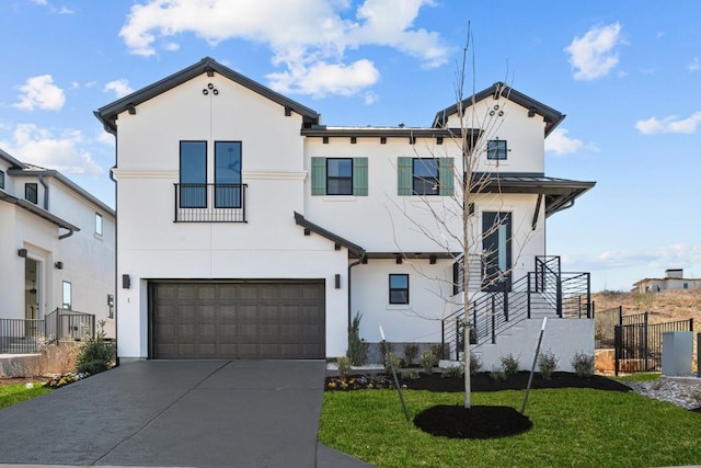 view of front of home with fence, concrete driveway, a front yard, stucco siding, and an attached garage