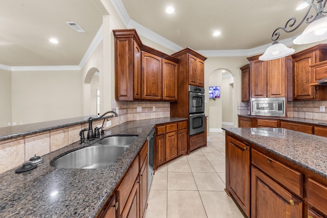 kitchen with ornamental molding, sink, pendant lighting, appliances with stainless steel finishes, and backsplash