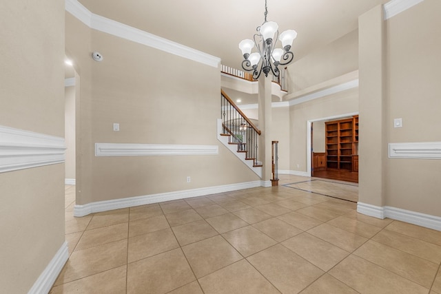 tiled foyer entrance with a notable chandelier and ornamental molding