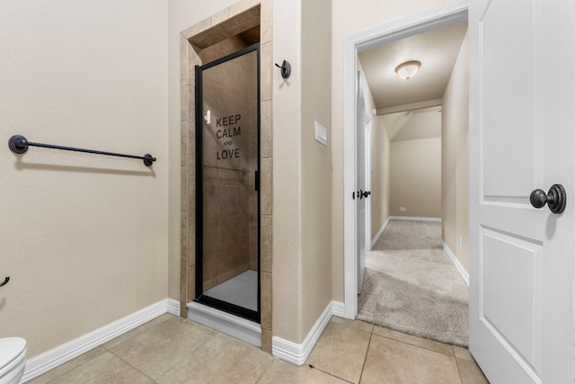 bathroom with tile patterned floors, an enclosed shower, and toilet