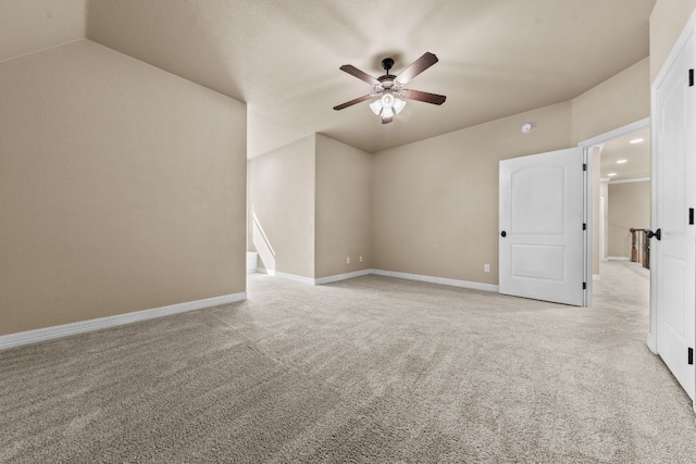 carpeted spare room with ceiling fan and lofted ceiling