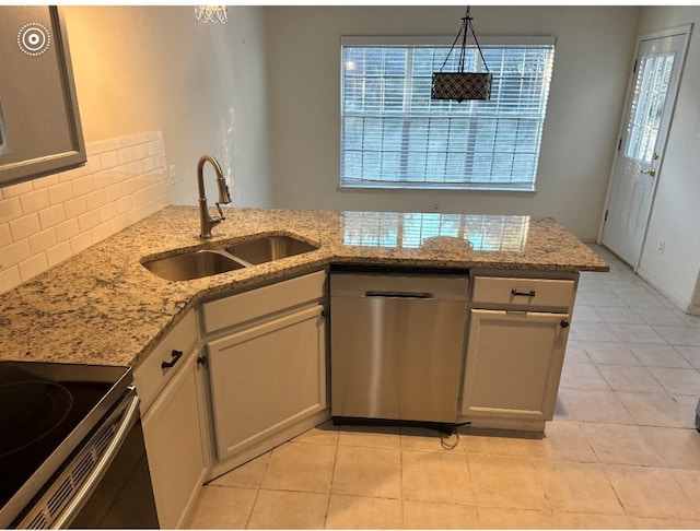 kitchen featuring light stone countertops, dishwasher, sink, kitchen peninsula, and pendant lighting