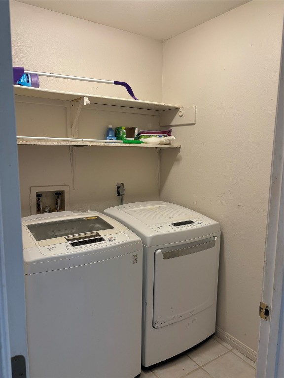 washroom featuring washing machine and clothes dryer and light tile patterned floors