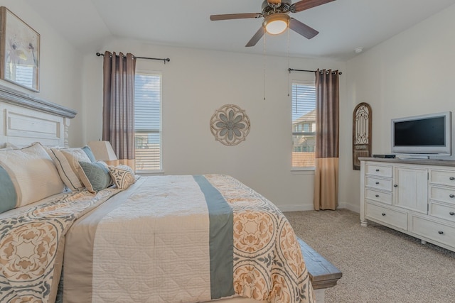 bedroom with light carpet, multiple windows, lofted ceiling, and ceiling fan