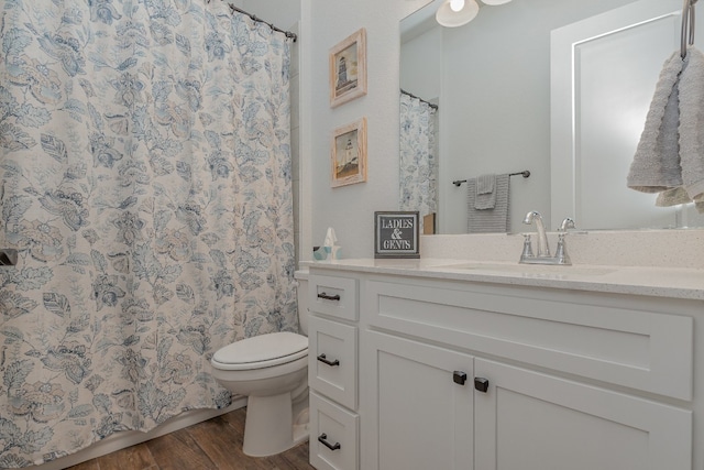 bathroom with hardwood / wood-style floors, vanity, and toilet