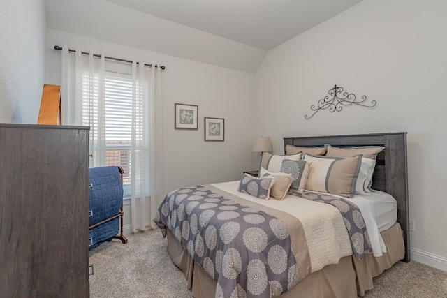 carpeted bedroom with lofted ceiling