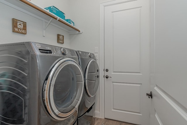 laundry room with washing machine and dryer and hardwood / wood-style flooring