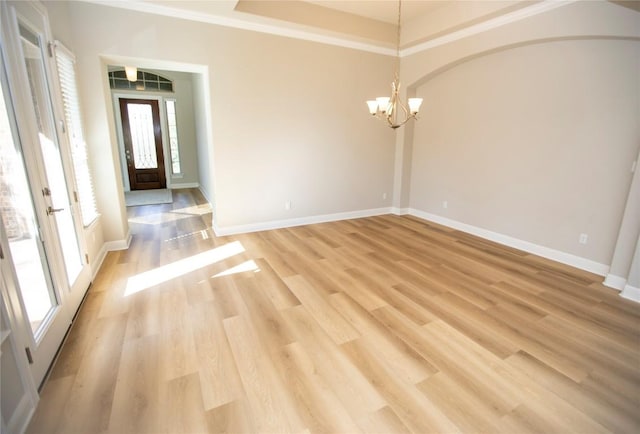 unfurnished room with ornamental molding, a chandelier, and light wood-type flooring