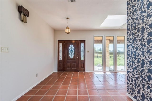 foyer with a skylight and tile patterned flooring